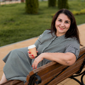 brunette-smiley-woman-holding-cup-coffee-outside.jpg